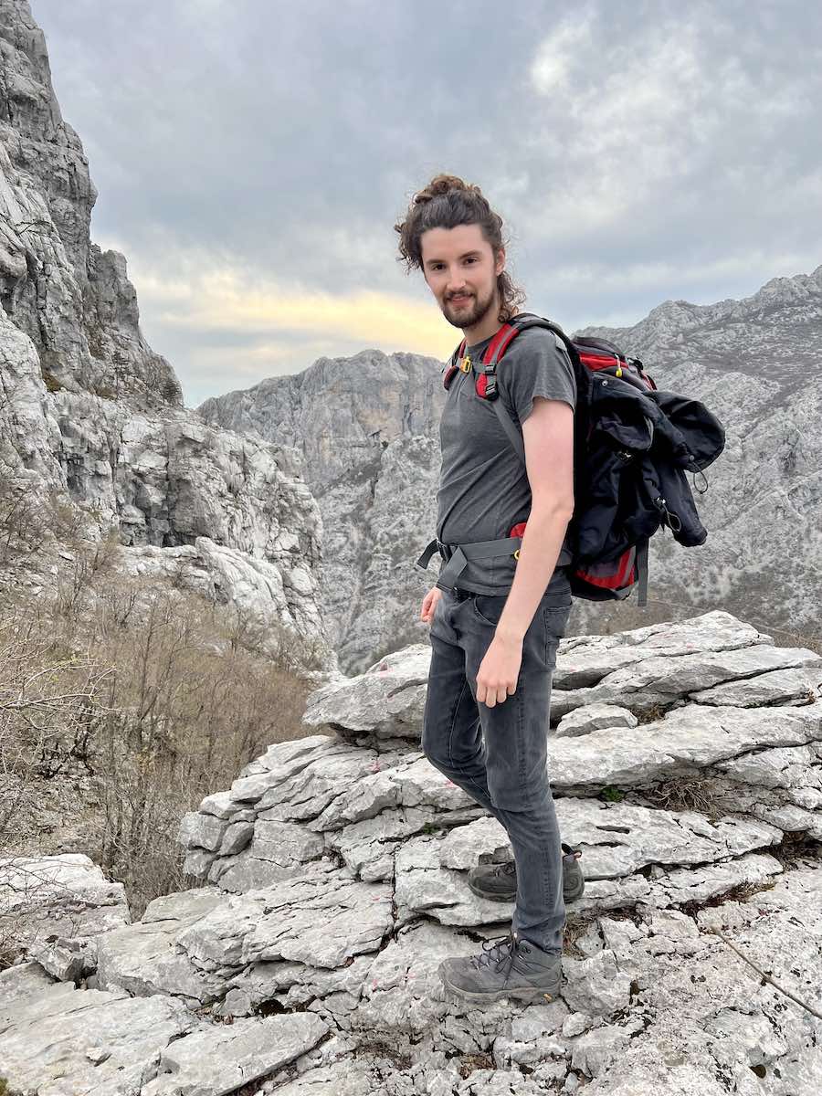 Nick smiling while hiking on a mountain